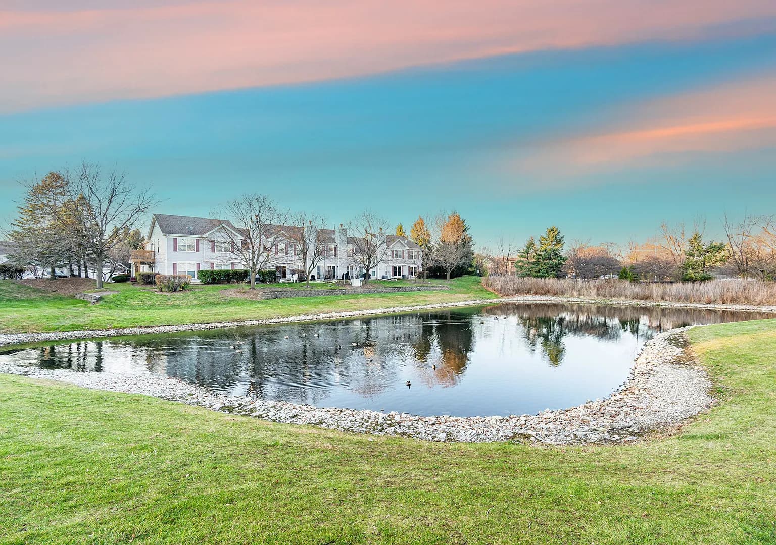 Community pond and landscaped common grounds near the townhome