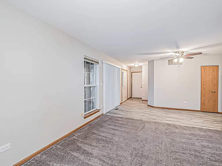 Open living and dining room with large windows and fresh paint