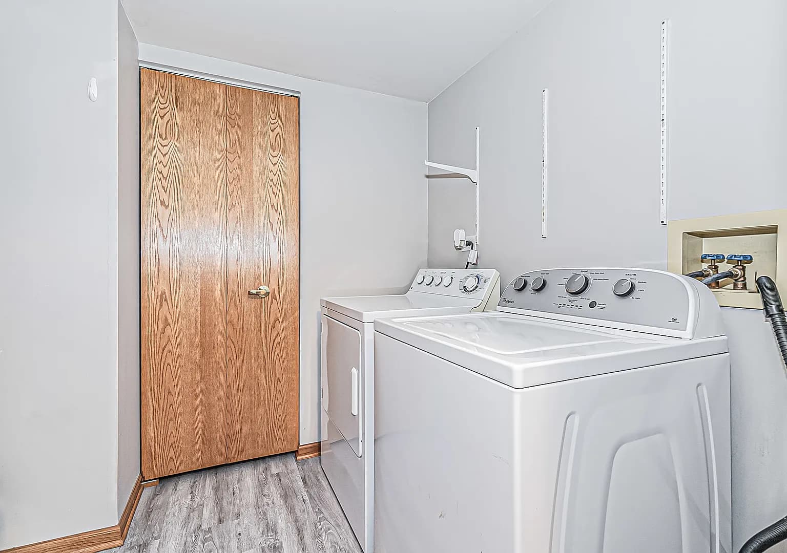 Separate in-unit laundry room with washer, dryer, and storage closet